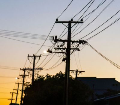 A line of utility poles, Cloud & Infrastructure | DXC Technology businessman standing outside checking smart phone, Cloud & Infrastructure | DXC Technology Customer Story